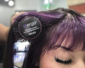 Hairdresser using a Ergo brush, an exhibitor at HairCon.