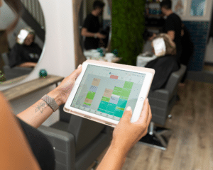 Vagaro salon software being used on an tablet, used at numerous salon around the world. Vagaro is an exhibitor and partner at HairCon.