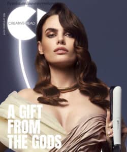 Creative Head magazine cover, with brown haired model holding hair straighteners. Creative Head are a media partner at HairCon.