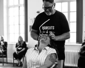 Woman having a Haircut by Haircuts 4 Homeless founder Stuart Roberts. A charity supporting HairCon.
