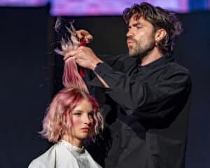 Guy Kleinhaus cutting a models hair on the live stage at HairCon, Manchester 2024.